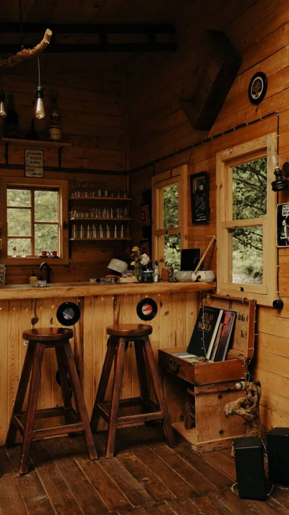 Warm wooden home bar with stools and backlit shelving
