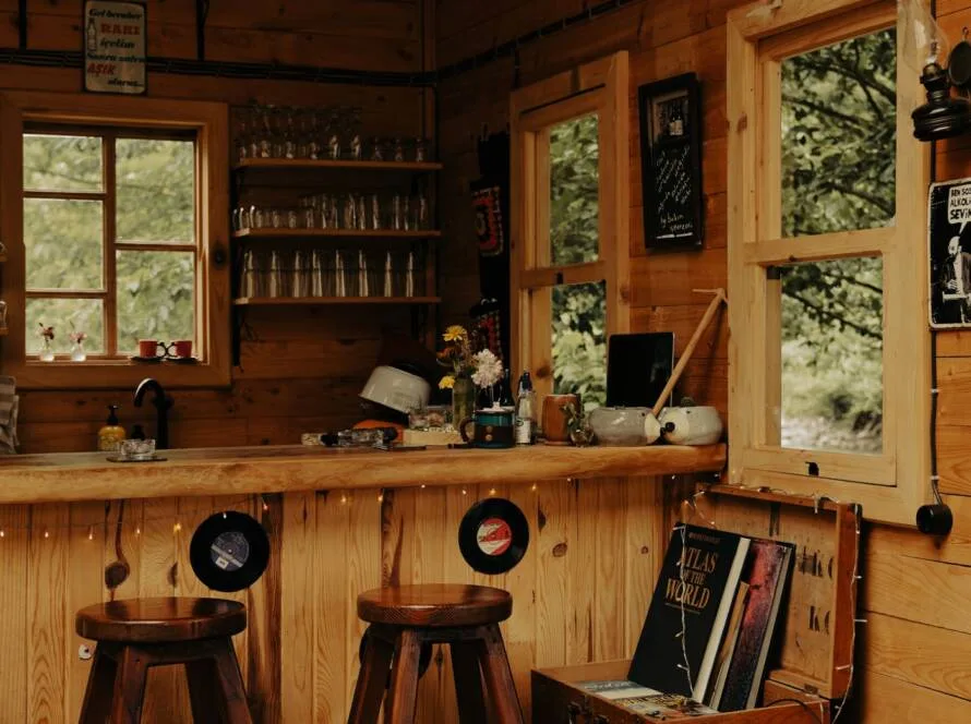 Warm wooden home bar with stools and backlit shelving