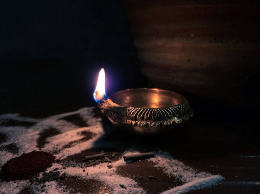 Warm glowing brass diya lamp — a calm, sacred corner in an Indian home