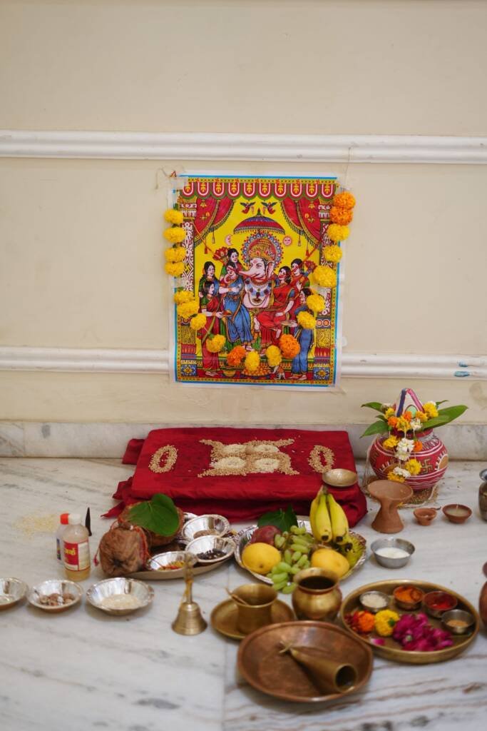 Traditional pooja setup with flowers, lamps and offerings in an Indian home