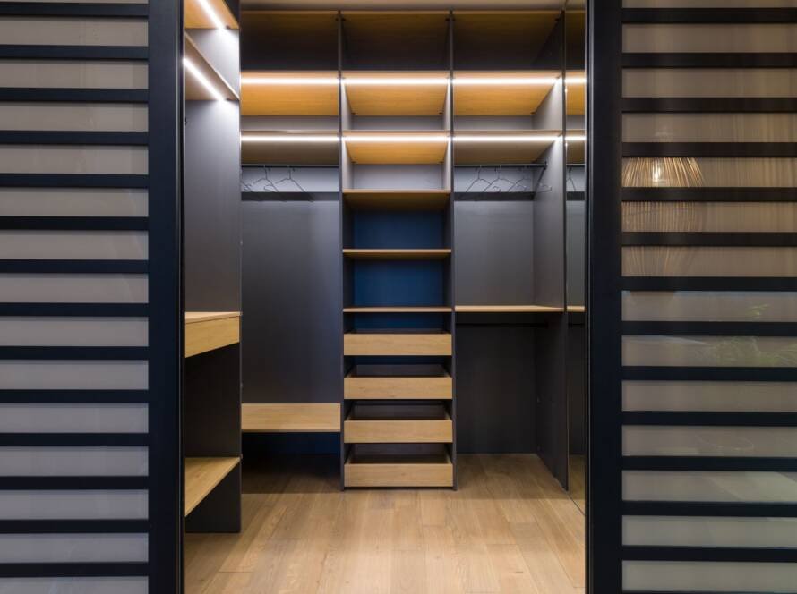 Luxury walk-in wardrobe with warm wooden shelving and hanging space