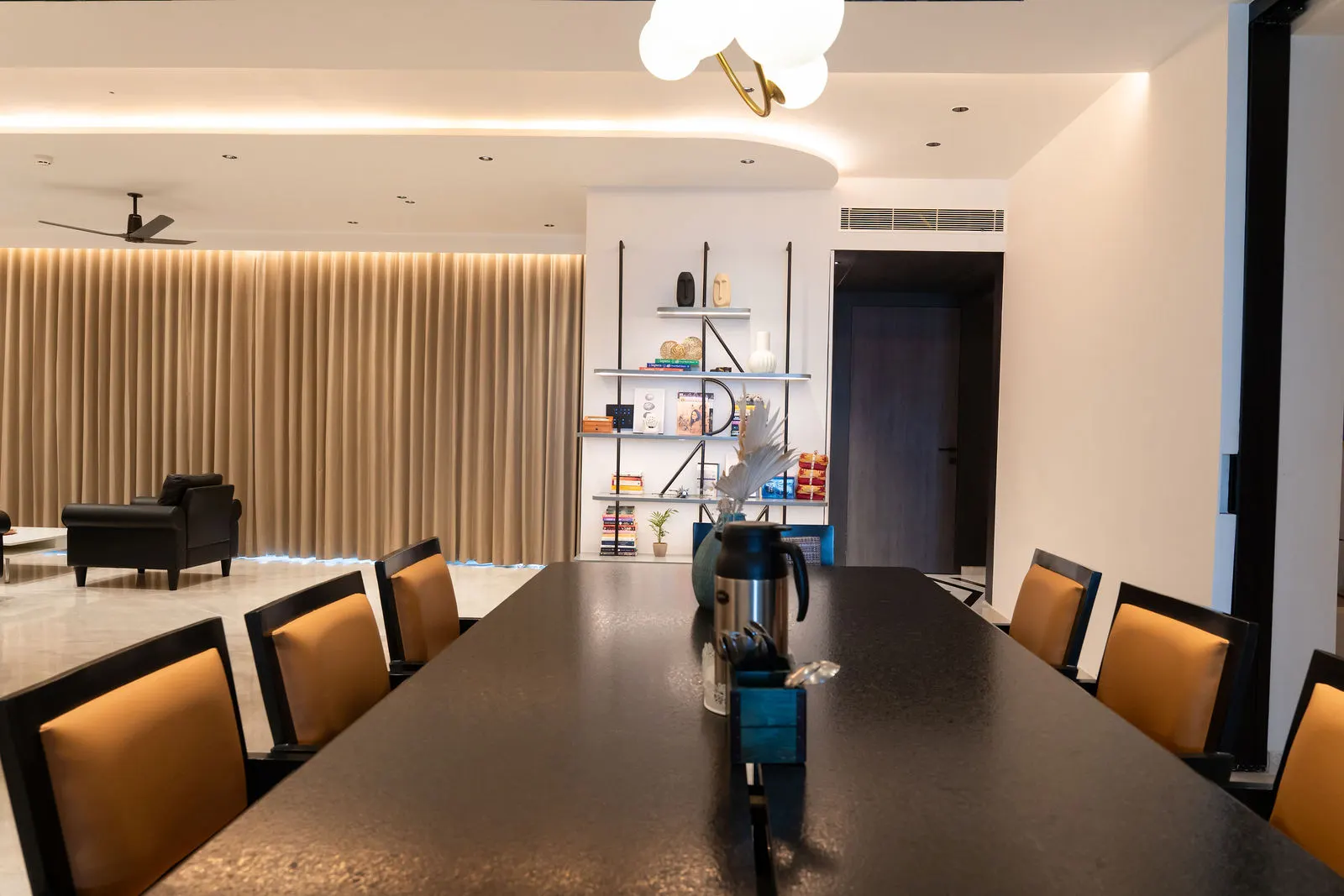 Eight-seater dining table under linear lighting