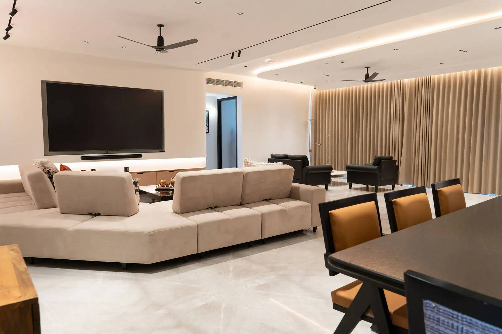 Living room with floor-to-ceiling curtains behind the TV wall