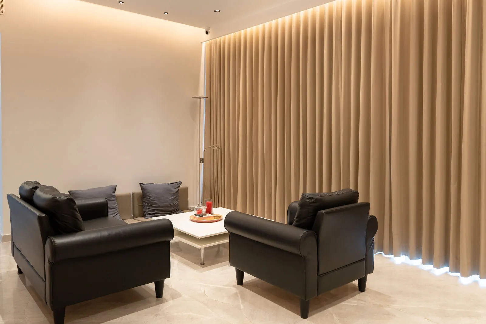 Fluted wood panelling behind a pair of dark armchairs