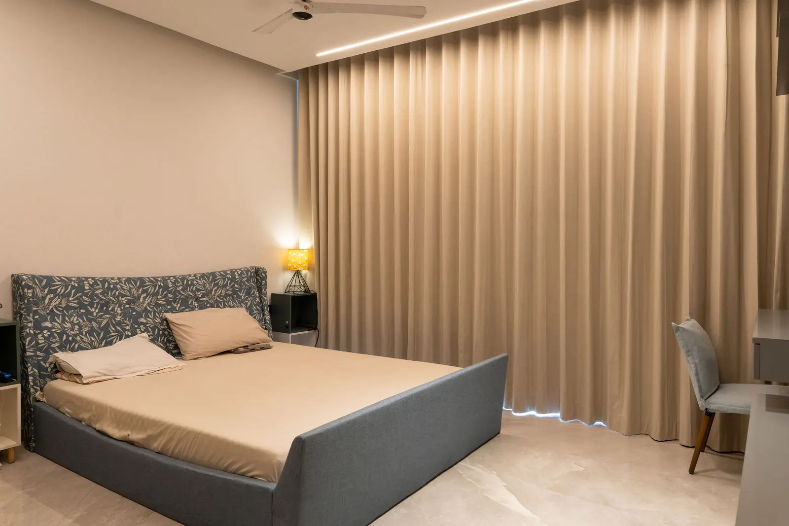 Master bedroom with upholstered bed and fluted curtain wall