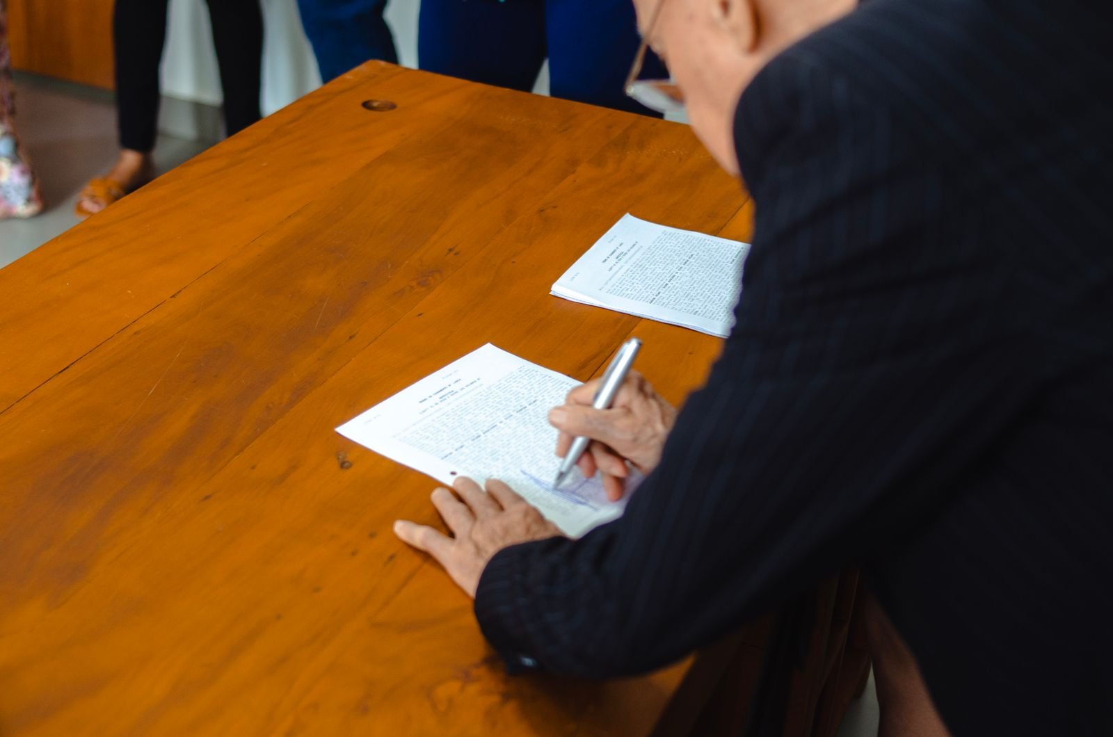 Signing official property documents at a wooden desk in India