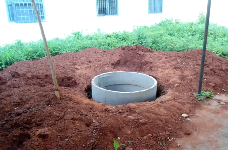 A rainwater harvesting recharge pit under construction on a site in India