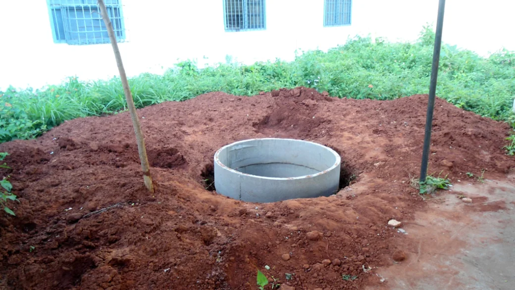 A rainwater harvesting recharge pit under construction on a site in India